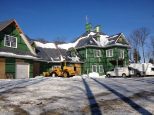 Exterior of large new construction home during insulation installation