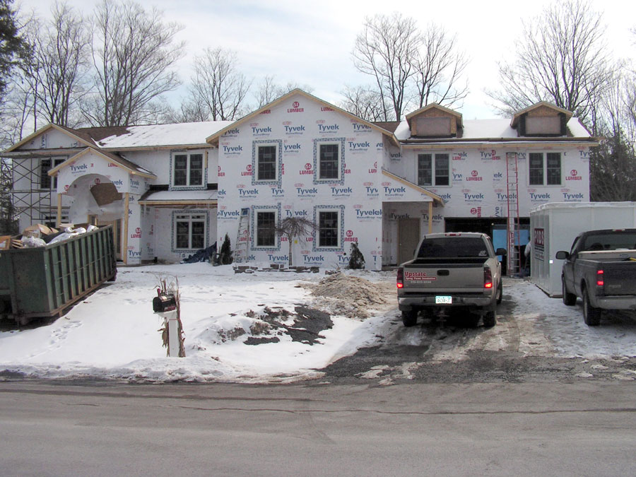 Exterior of large home renovation during insulation installation and before siding is installed